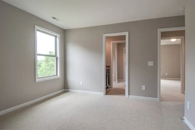 a view of an empty room with window and closet area
