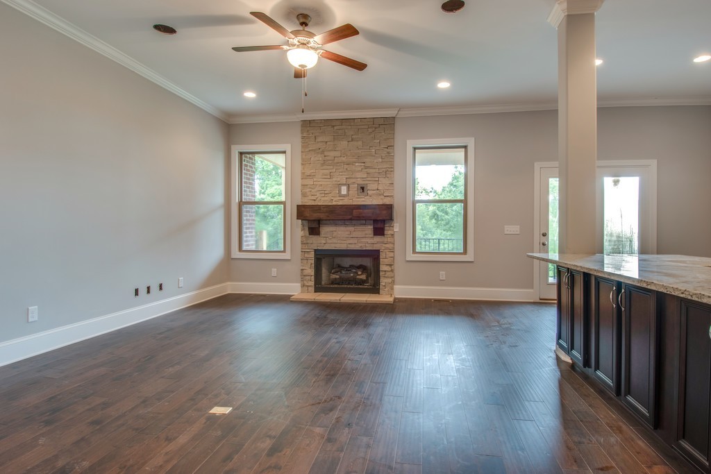 942 Hunters Lane Springfield, TN 37172 - Photo 4 of 40 an empty room with wooden floor fireplace and windows