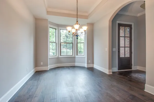 a view of a room with wooden floors and chandelier