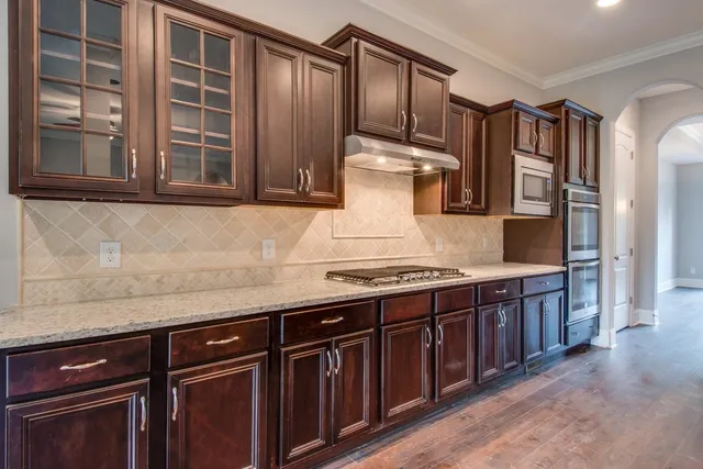 a kitchen with stainless steel appliances granite countertop a stove and a sink