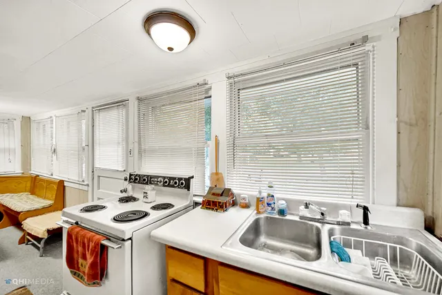 a kitchen that has a sink a stove and a table with chairs