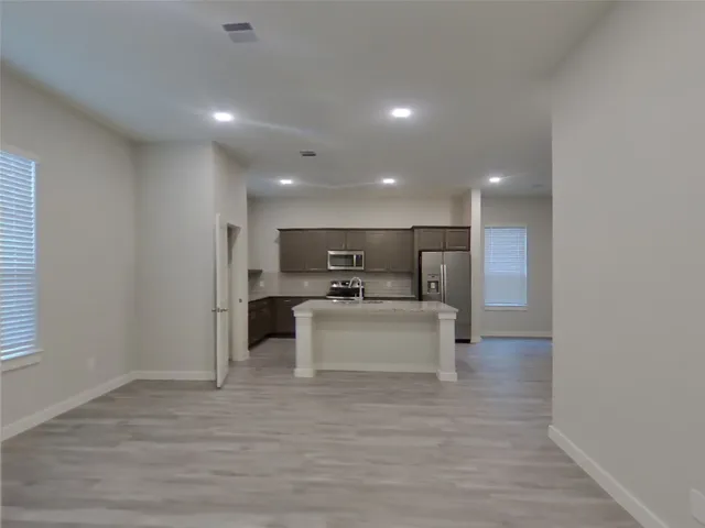 a view of kitchen with microwave oven on dining table and chairs