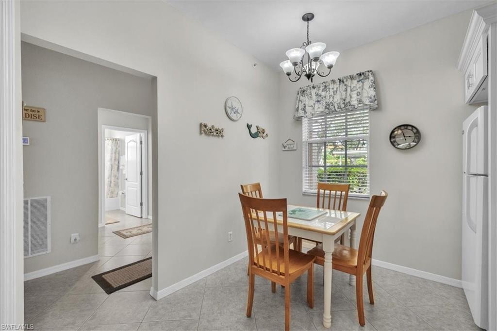 8075 Tiger Cove, Unit 1706 Naples, FL 34113 - Photo 12 of 50 Dining room with light tile patterned flooring and a chandelier