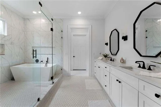 a bathroom with a double vanity sink mirror and bathtub