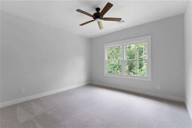 an empty room with a window and a fan