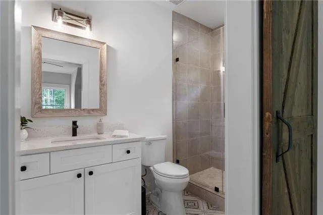 a bathroom with a toilet sink vanity and mirror