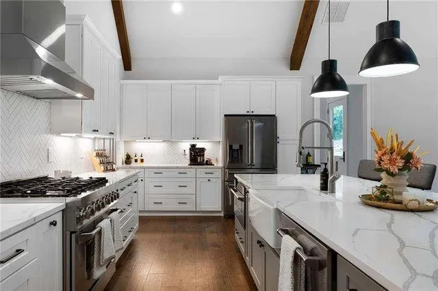 a kitchen with a sink dishwasher a stove a refrigerator and cabinets