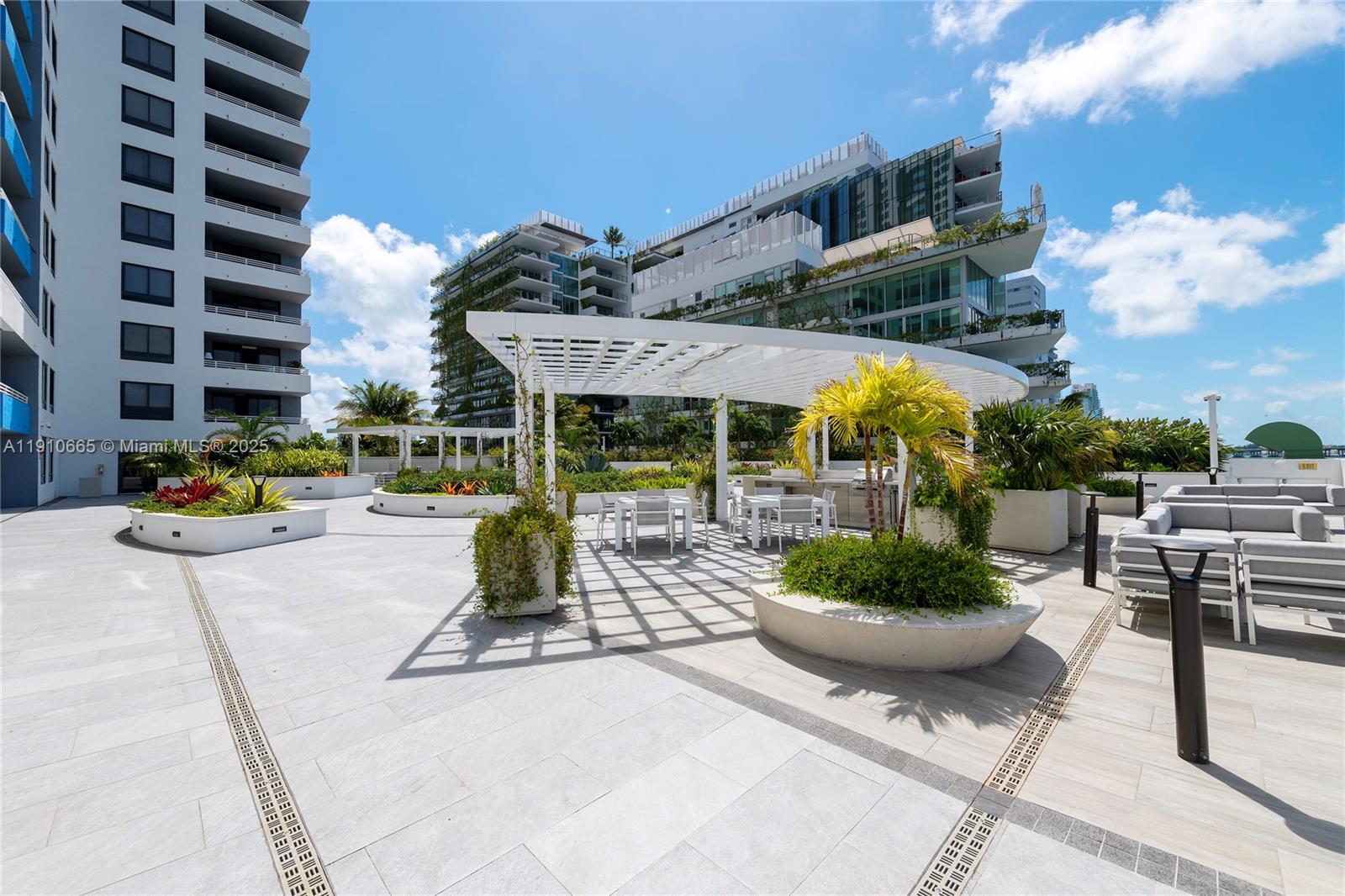 1330 West Avenue, Unit 3104 Miami Beach, FL 33139 - Photo 14 of 18 a view of a patio with a table and chairs and potted plants