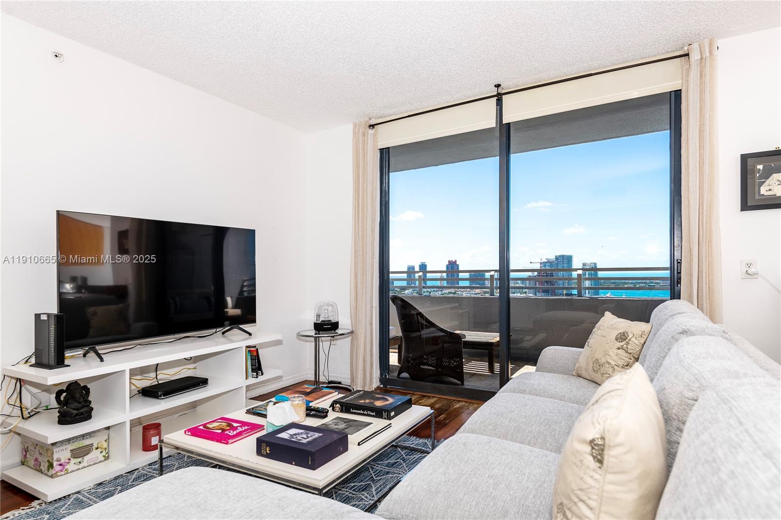 1330 West Avenue, Unit 3104 Miami Beach, FL 33139 - Photo 2 of 18 a living room with furniture and a flat screen tv
