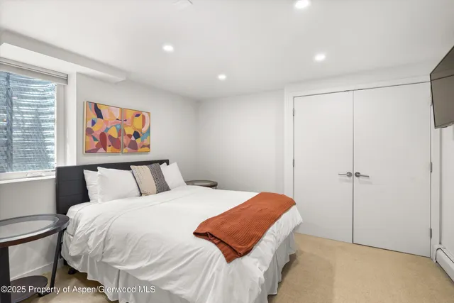 a bedroom with a bed and a painting on the wall