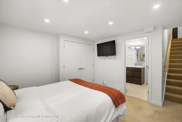 a bedroom with a bed and a flat screen tv