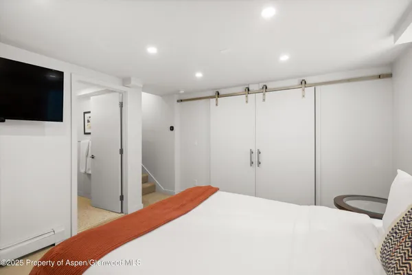 a bedroom with a bed and a flat screen tv