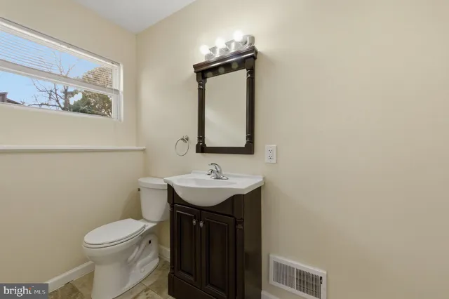a bathroom with a toilet sink and mirror
