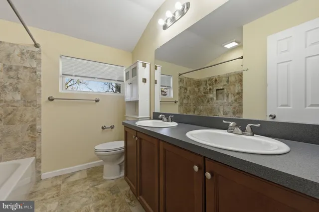 a bathroom with a granite countertop sink toilet and shower