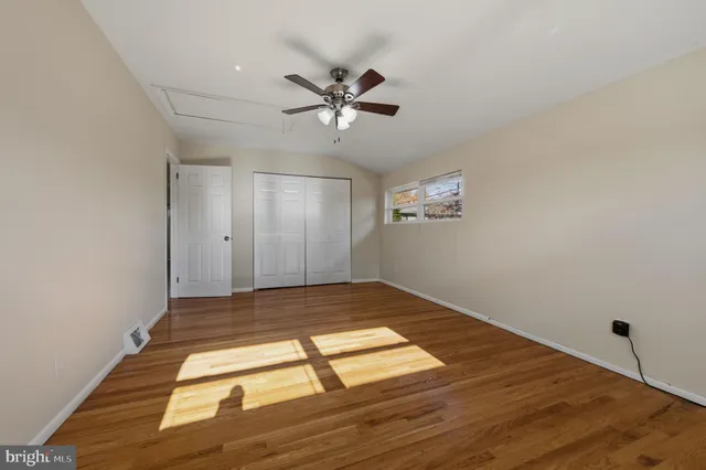 a view of empty room with wooden floor