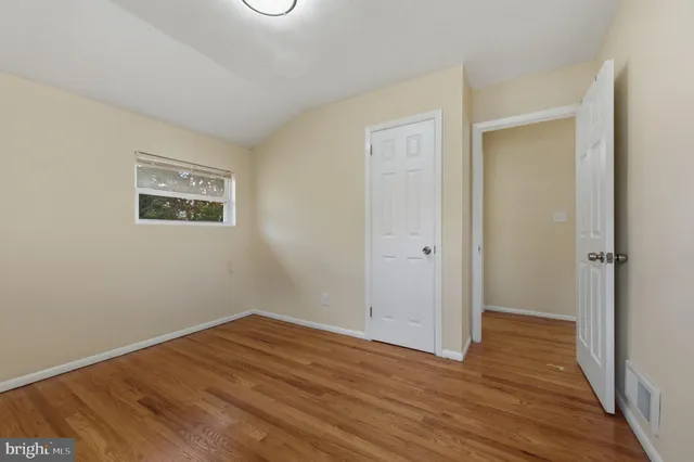 a view of an empty room with wooden floor