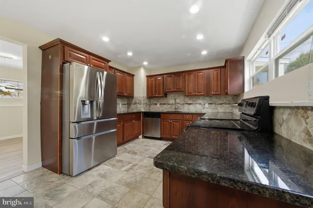 a kitchen with granite countertop stainless steel appliances and wooden cabinets