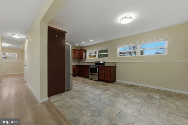 a large kitchen with stainless steel appliances granite countertop a refrigerator and a sink