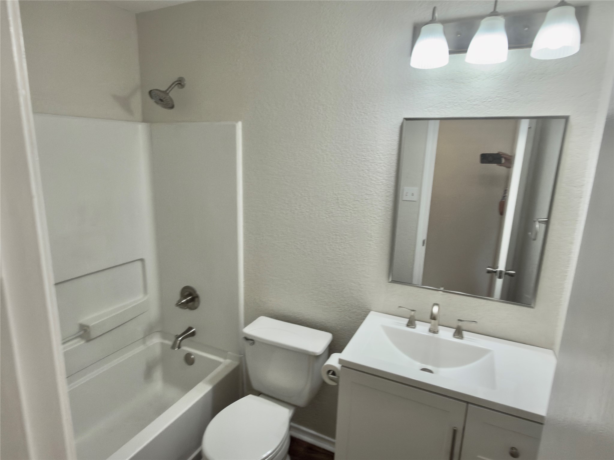 255 Myrtle Street Kyle, TX 78640 - Photo 21 of 31 Bathroom featuring a white vanity with integrated sink, brushed nickel faucet, and a wall-mounted mirror