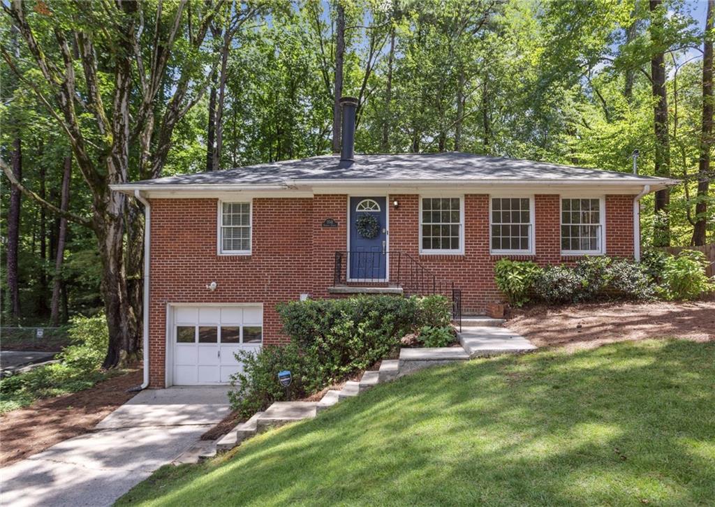 3541 Hamlin Circle Chamblee, GA 30341 - Photo 1 of 1 a view of a brick house next to a yard with potted plants and large trees