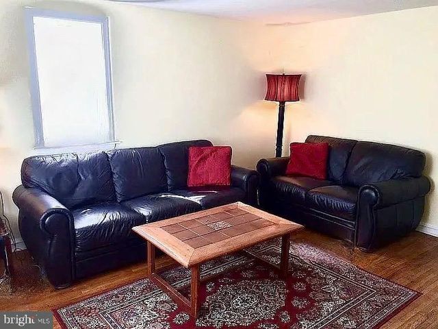 a living room with furniture a rug and a lamp