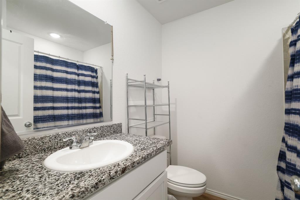 1445 Sterling Way Ferris, TX 75125 - Photo 12 of 17 a bathroom with a sink a toilet a mirror and shower