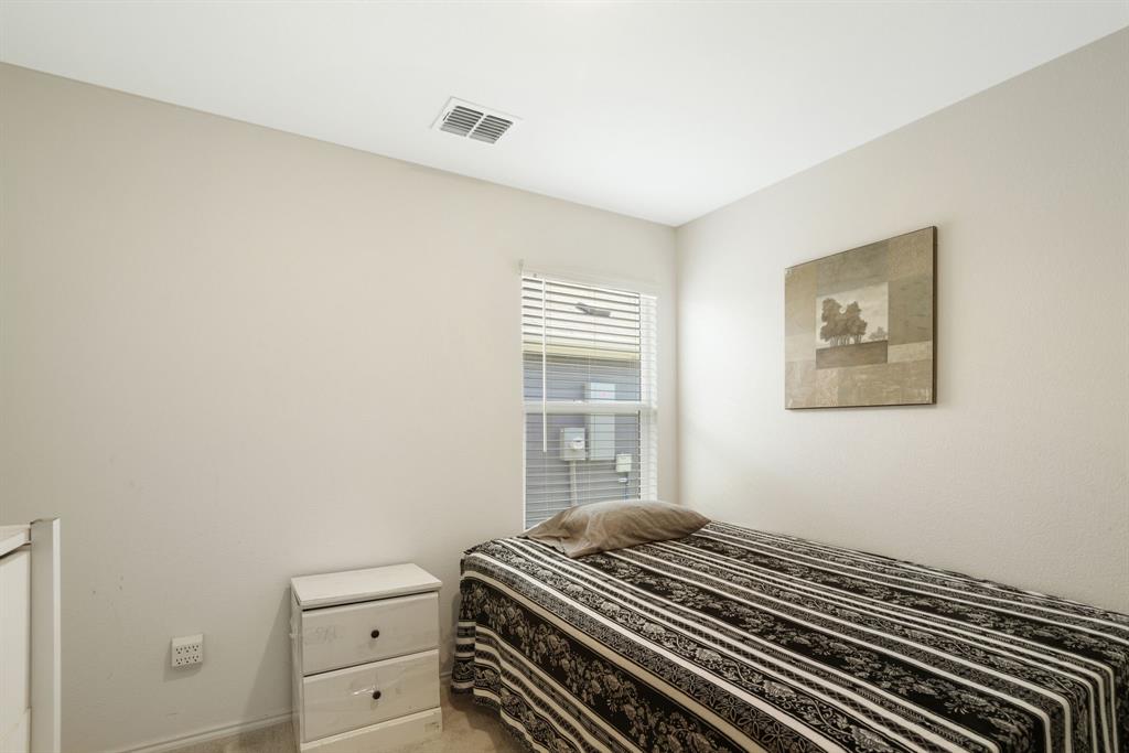 1445 Sterling Way Ferris, TX 75125 - Photo 14 of 17 a bedroom with a bed and a window