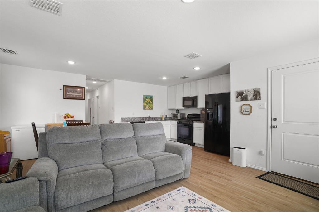 1445 Sterling Way Ferris, TX 75125 - Photo 5 of 17 a living room with furniture and a refrigerator