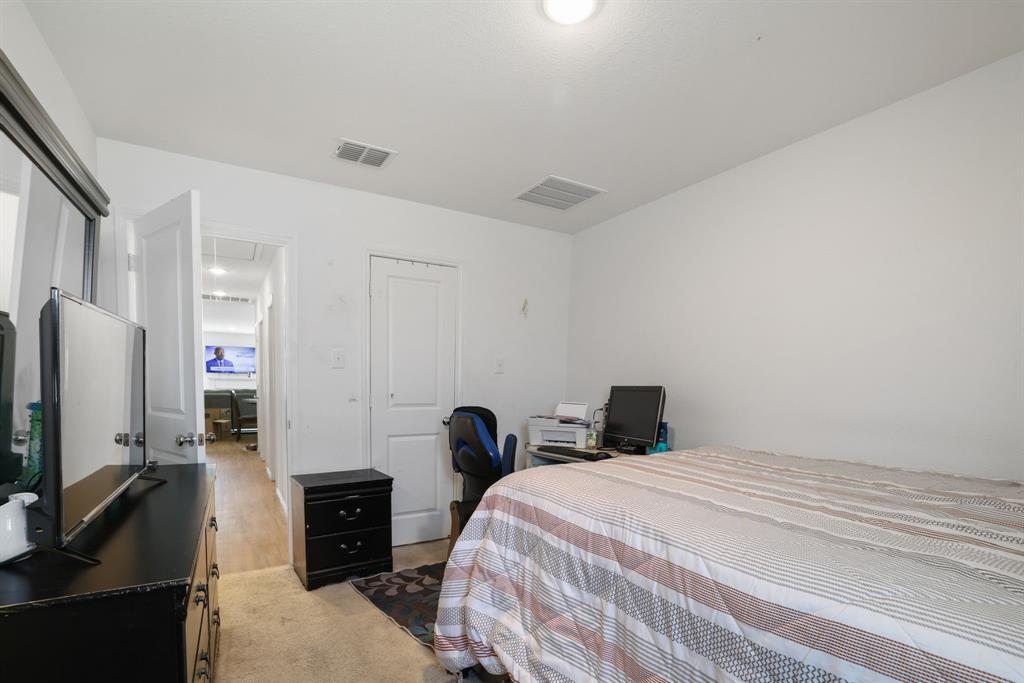 1445 Sterling Way Ferris, TX 75125 - Photo 10 of 17 a bedroom with a bed and a flat screen tv