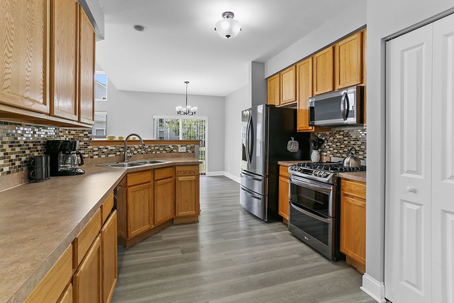 7007 Creekside Drive Plainfield, IL 60586 - Photo 8 of 21 a kitchen with stainless steel appliances granite countertop a stove refrigerator and a sink