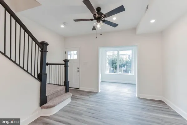 a kitchen with stainless steel appliances granite countertop a sink a stove a refrigerator and white cabinets