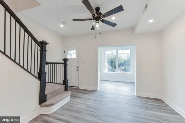 a kitchen with stainless steel appliances granite countertop a sink a stove a refrigerator and white cabinets