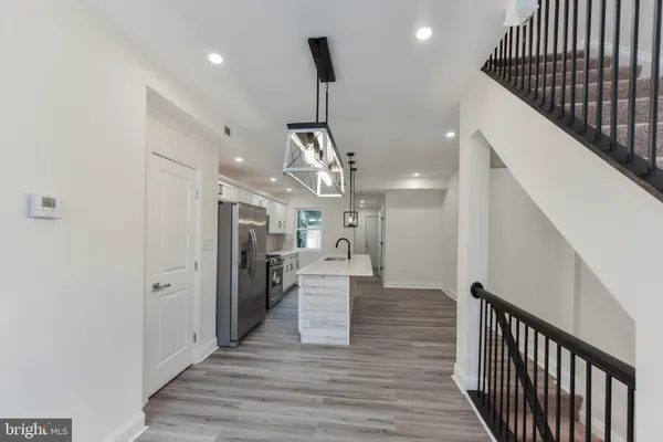 a view of entryway and kitchen with wooden floor