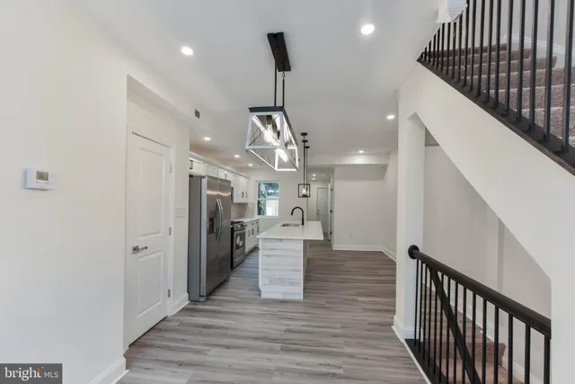 a view of entryway and kitchen with wooden floor