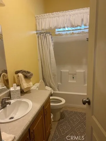 a bathroom with a granite countertop sink mirror vanity and toilet