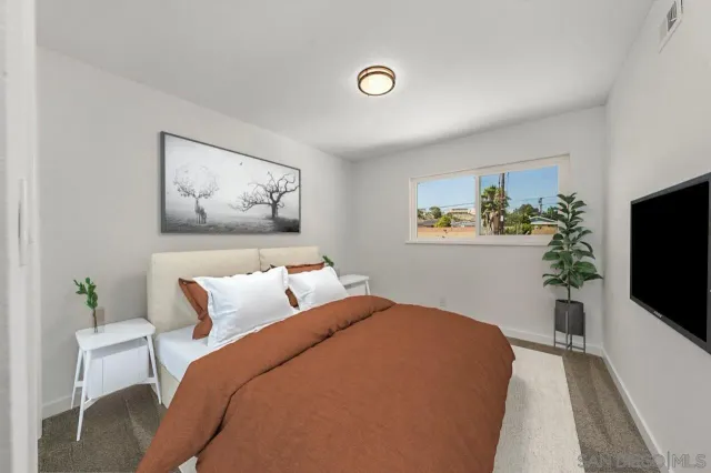 a bedroom with a bed and a flat screen tv