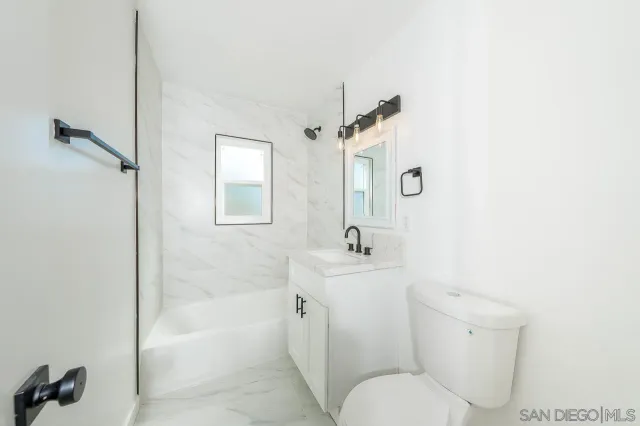 a white toilet sitting next to a bath tub