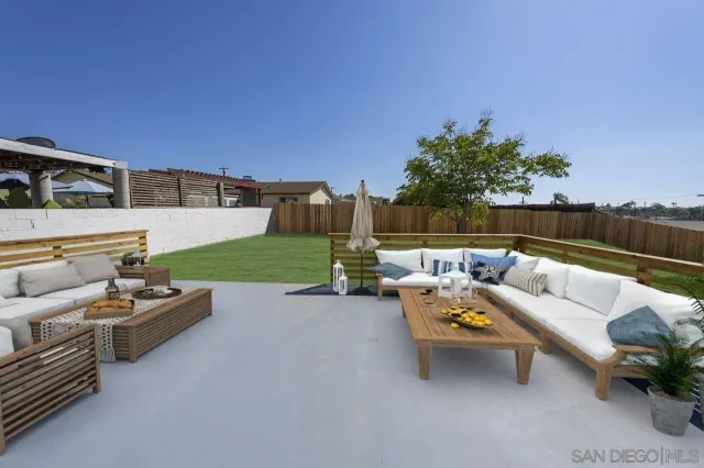a roof deck with couches and potted plants with sky view