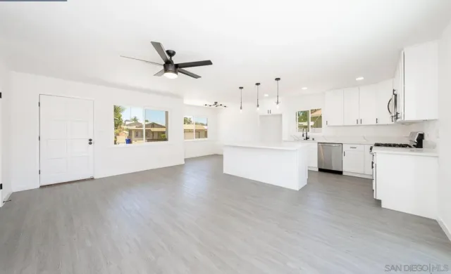 a view of a kitchen with a sink and dishwasher a stove with wooden floor