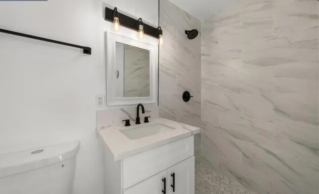 a bathroom with a sink a toilet and shower