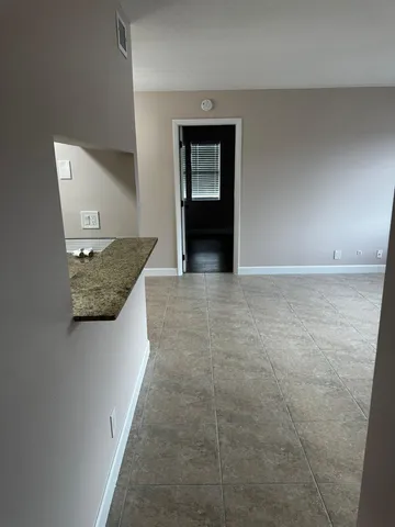 a view of hallway with a sink and a refrigerator