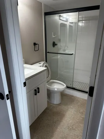 a bathroom with a granite countertop sink toilet and shower