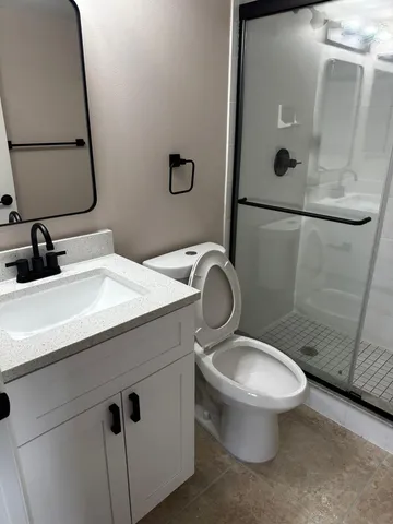 a bathroom with a sink toilet and mirror