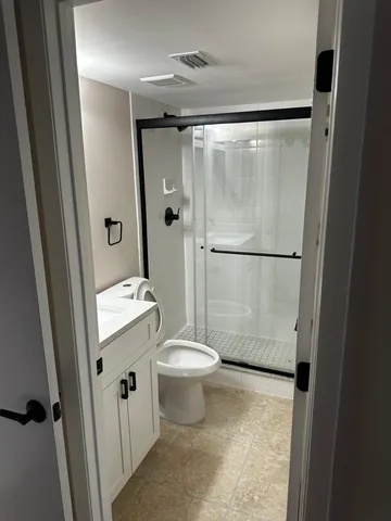 a bathroom with a granite countertop sink toilet and shower