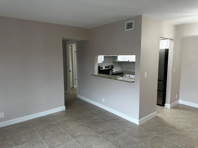 a view of a kitchen with a refrigerator and a sink