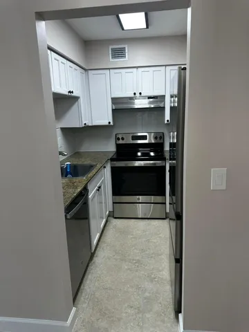 a kitchen with stainless steel appliances a stove and more cabinets