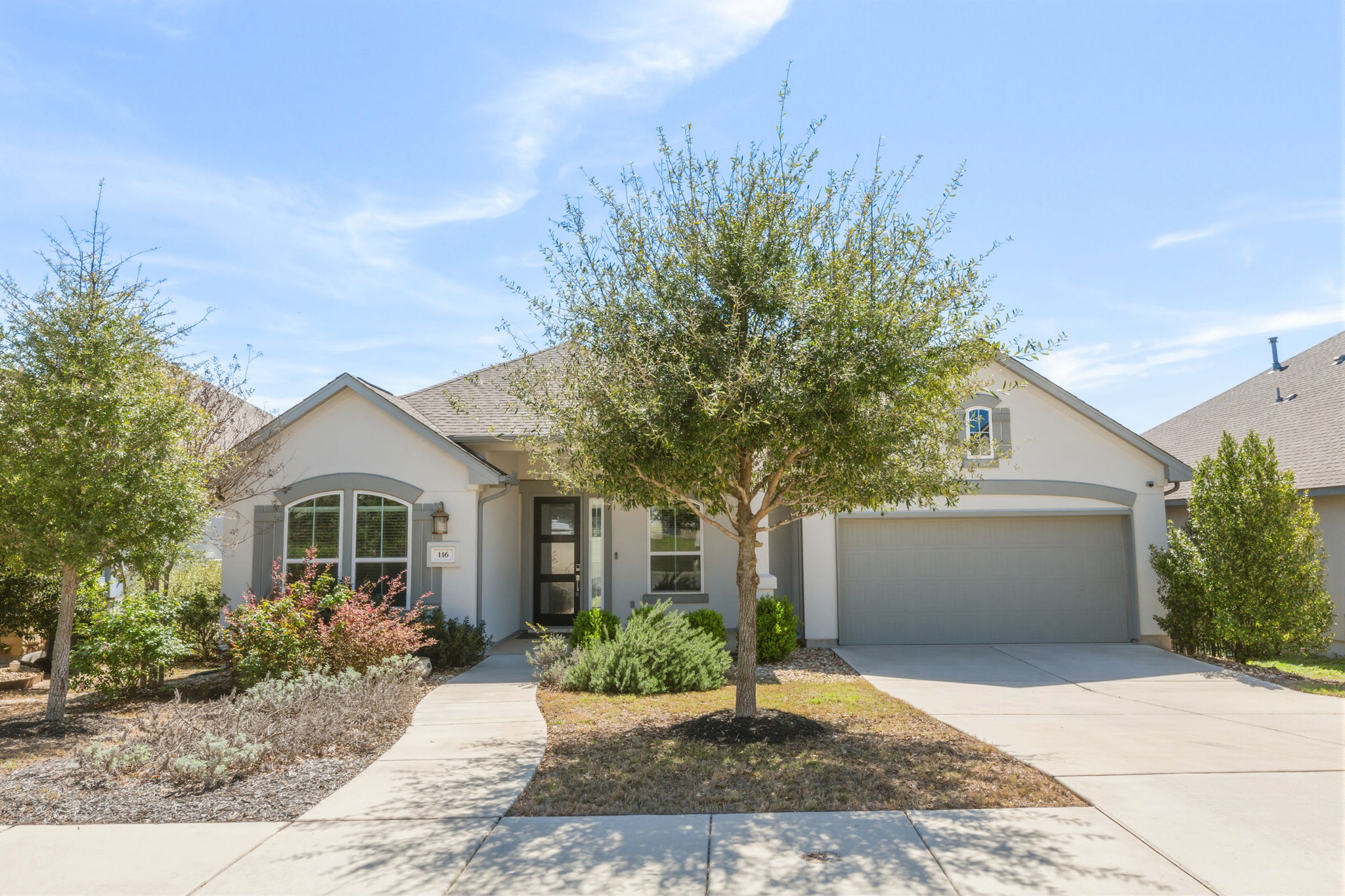 View of front of property featuring concrete driveway, stucco siding, and an attached garage