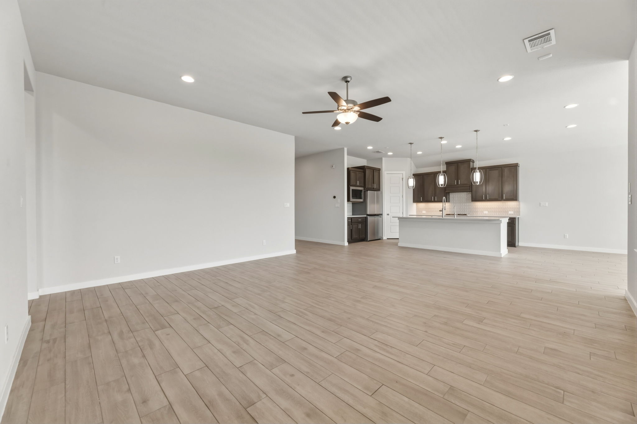 116 Tanali Trail Georgetown, TX 78628 - Photo 26 of 40 Unfurnished living room with a ceiling fan, light wood-style flooring, and recessed lighting