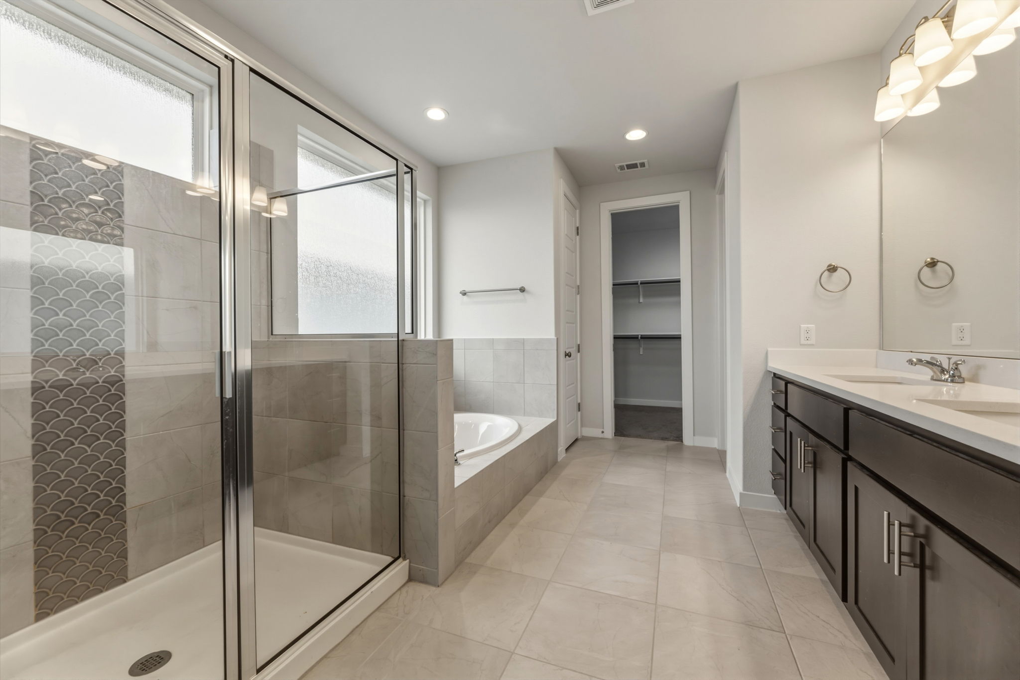 116 Tanali Trail Georgetown, TX 78628 - Photo 30 of 40 Bathroom featuring double vanity, a garden tub, a spacious closet, a shower stall, and recessed lighting