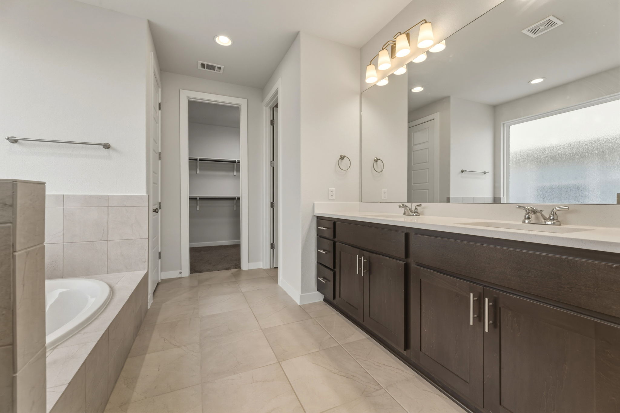 116 Tanali Trail Georgetown, TX 78628 - Photo 32 of 40 Bathroom featuring double vanity, a spacious closet, a bath, and recessed lighting